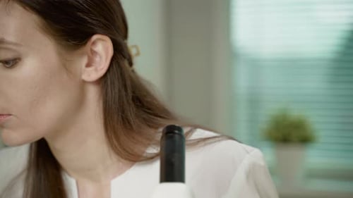 Woman Analyzing Sample Through Microscope in Laboratory