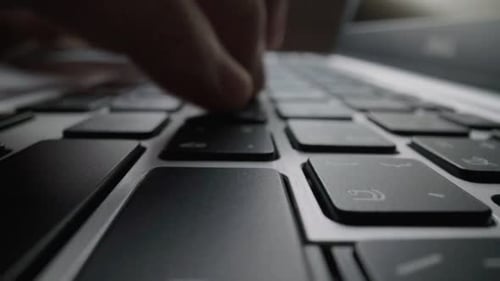 Close-up typing on keyboard with man fingers. Macro soft focus dolly shot.