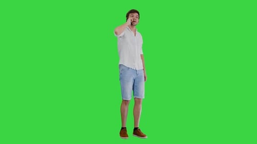 Joven feliz hablando por teléfono móvil y sonriendo en una pantalla verde, Chroma Key.