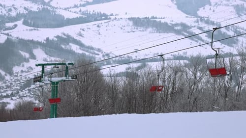 View of the Ski Lift Against the Background of a Mountain Forest and Gray Sky in the Carpathians