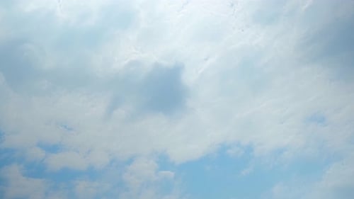 Fluffy White Clouds Float in Blue Sky