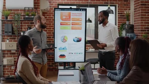 Corporate Team Discusses Analytics Data in Modern Office