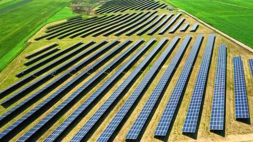 Aerial view of solar panels on green field