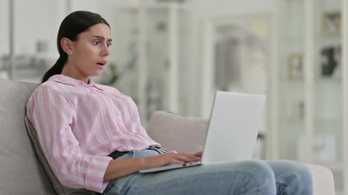 Woman on Sofa Upset by Laptop Content