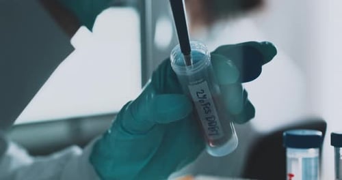 Scientist Adding Liquid to Test Tube in Lab