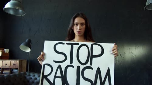 Woman Holding Stop Racism Sign Indoors
