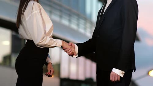 Handshake Between Business Man and Business Woman Outdoors By Business Building