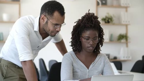 Front View of Two Concentrated People Working with Laptop