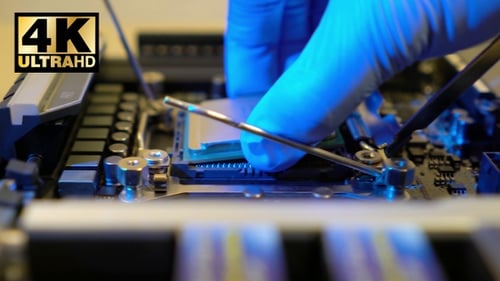 Technician Installing Computer Chip on Motherboard