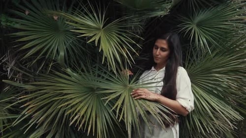 Model Posing with a Palm in Garden.
