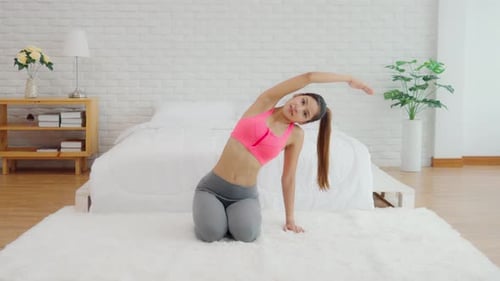 Fit Woman Stretching in Bedroom