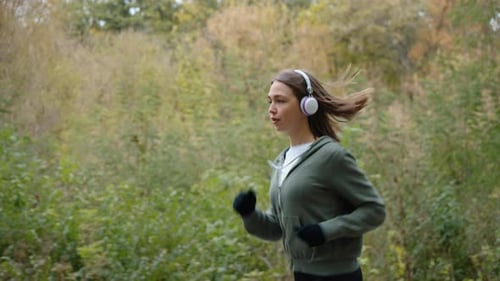 Female Jogger Listening to Audio Book While Exercising