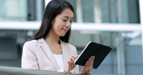 Woman Using Tablet in Modern Building