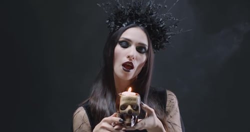 Mysterious Woman Blowing Out Skull Candle