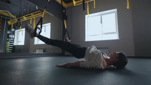 Sporty Woman Doing TRX Exercises in the Gym