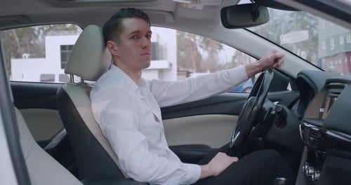 Man in car experiences frustration, covers face in despair