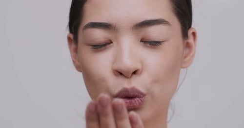 Close Up Portrait of Asian Girl Sending Air Kiss To Camera