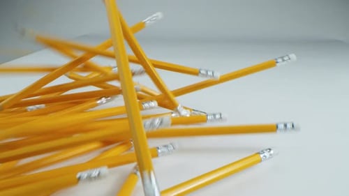 Yellow Pencils Falling onto White Surface