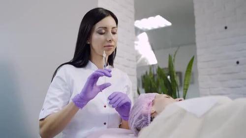 Cosmetician Injecting Facial Filler on Lying Woman