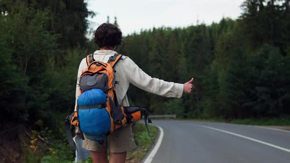 Girl Tourist Goes On Foot Hitchhiking Along The Highway Stopping Cars ...