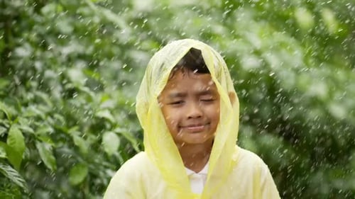 Smiling Child in Rain with Yellow Raincoat
