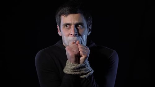 Un homme otage effrayé aux mains liées