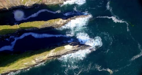 Aerial View of Waves Crashing on Rocky Cliffs