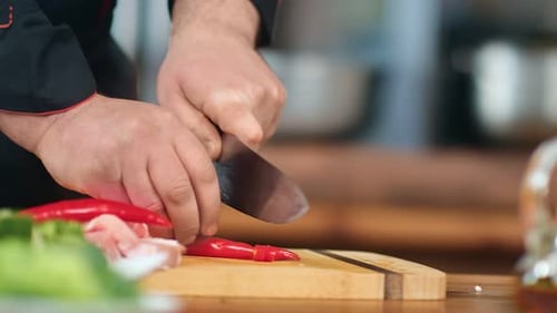Chef Dicing Red Chili Peppers on Cutting Board