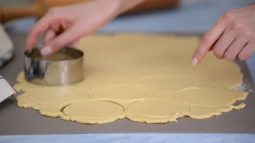 Woman Making Cookies with Cutter in Bright Kitchen