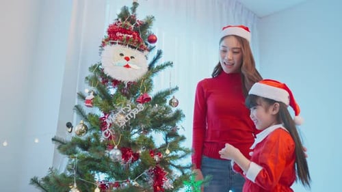 Woman and Child Decorate Christmas Tree Together