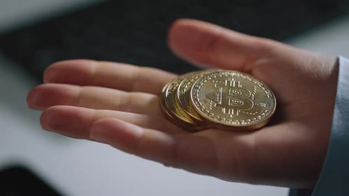 Hand Holding Stack of Golden Bitcoin Coins