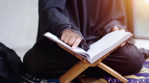Portrait of an Asian muslim women in a daily prayer at home reciting Surah al-Fatiha passage of the