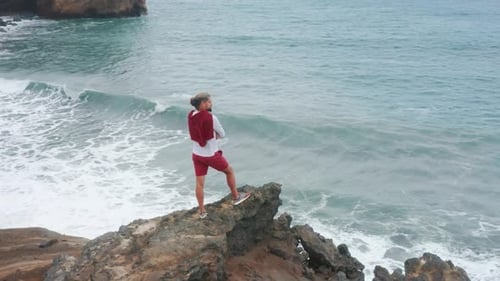 Homme debout sur une falaise de l'océan Atlantique au volcan Capelinhos sur l'île de Faial