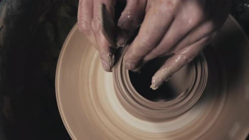 Potter façonne le produit en argile avec des outils de poterie sur le tour de potier Vue de dessus Cinématographique tonique