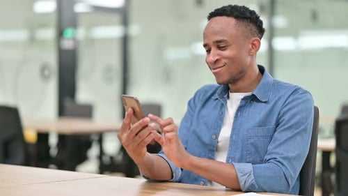 Focused Casual African Man Using Smartphone in Office