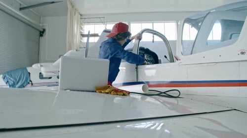 Female Engineer Using Laptop While Testing Airplane Engine