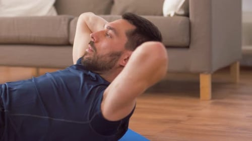 Homme faisant des exercices abdominaux à la maison 2