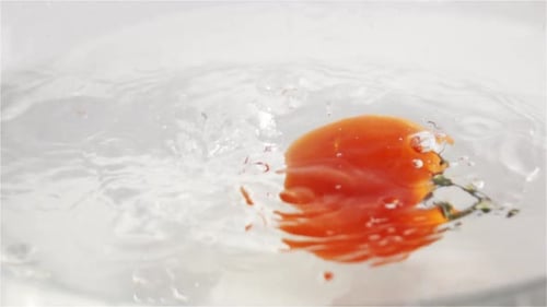 Fresh Red Tomatoes Dropping into a Bowl of Water
