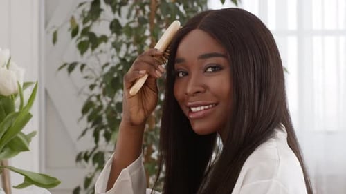 Woman Brushing Hair Smiling Beautifully