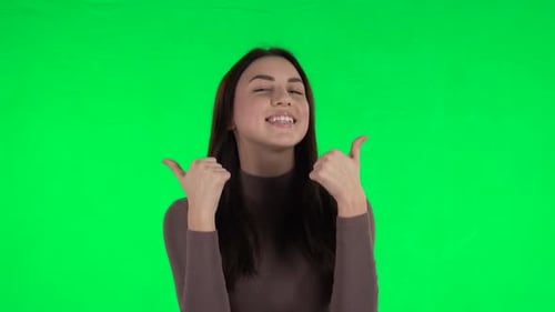 Attraktives Mädchen zeigt Daumen hoch, Gestenhaft. Greenscreen