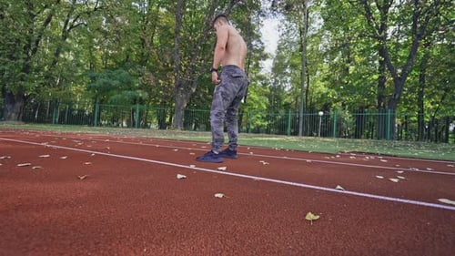 Athletic Man Running on a Track Outdoors