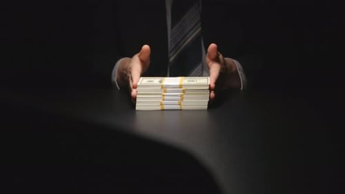 Man Hands Guarding Stack of Bound United States Dollars