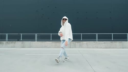 Fashionable Dancer Man in Sportswear and with Glasses Is Performing Outdoor Street Dancing Motion