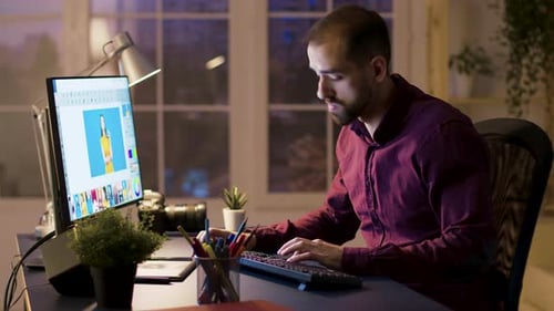 Man Edits Photos at Computer Late at Night