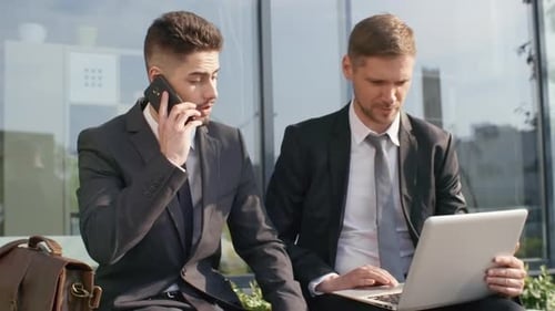 Collègues masculins occupés travaillant en extérieur