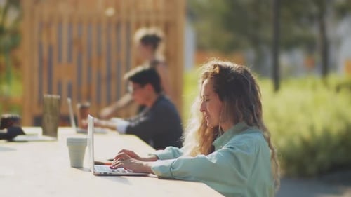 Woman Using Laptop while Working Remotely in Park