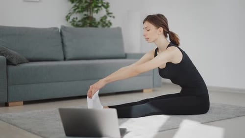 Woman Stretching During Online Fitness Class