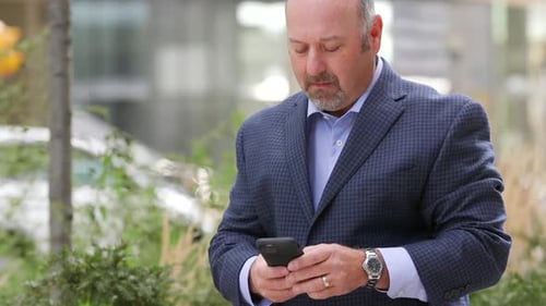 Homme détournant le regard puis lisant un message texte puis regardant autour de lui, inquiet
