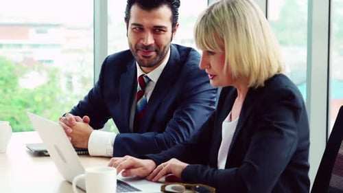 Two Business People Talk Project Strategy at Office