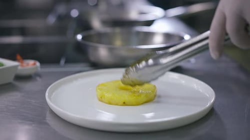 Side View Plate on Countertop with Male Hand in Glove Putting Pineapple and Fried Shrimps in Slow